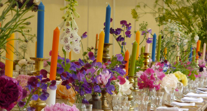 bright colour candles as centrepieces with vibrant floral decor