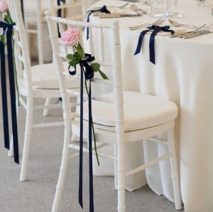 black ribbon on the back of a white tiffany chair